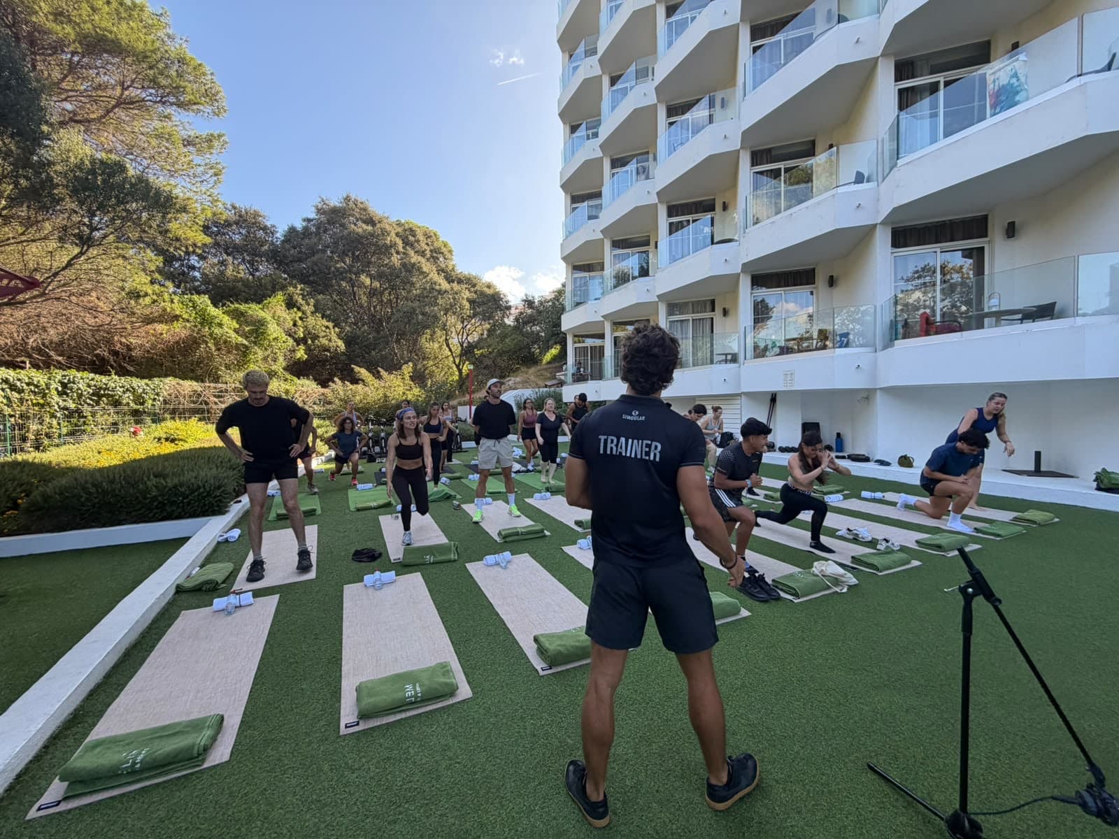 Clase de entrenamiento funcional en el jardín de un hotel