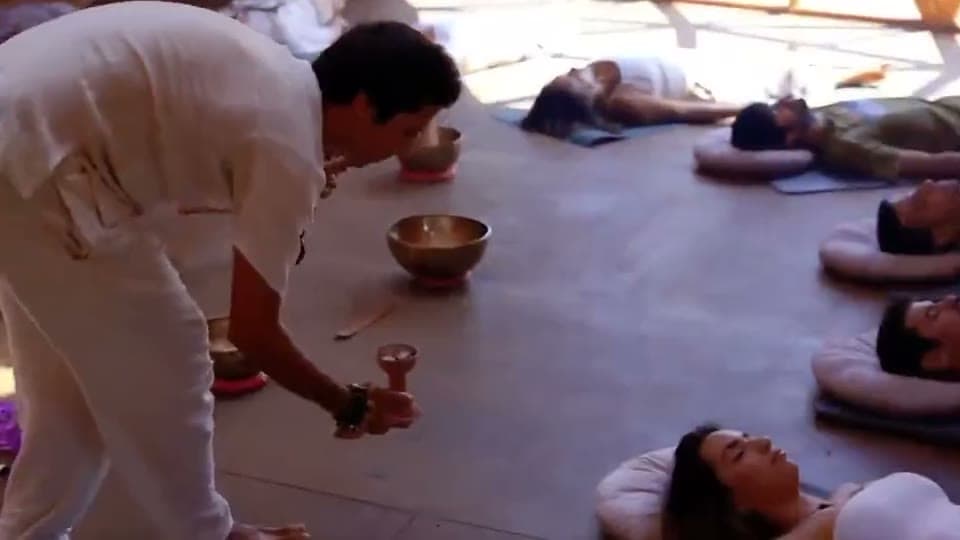 Sesión de sound healing para un grupo tumbado en esterillas