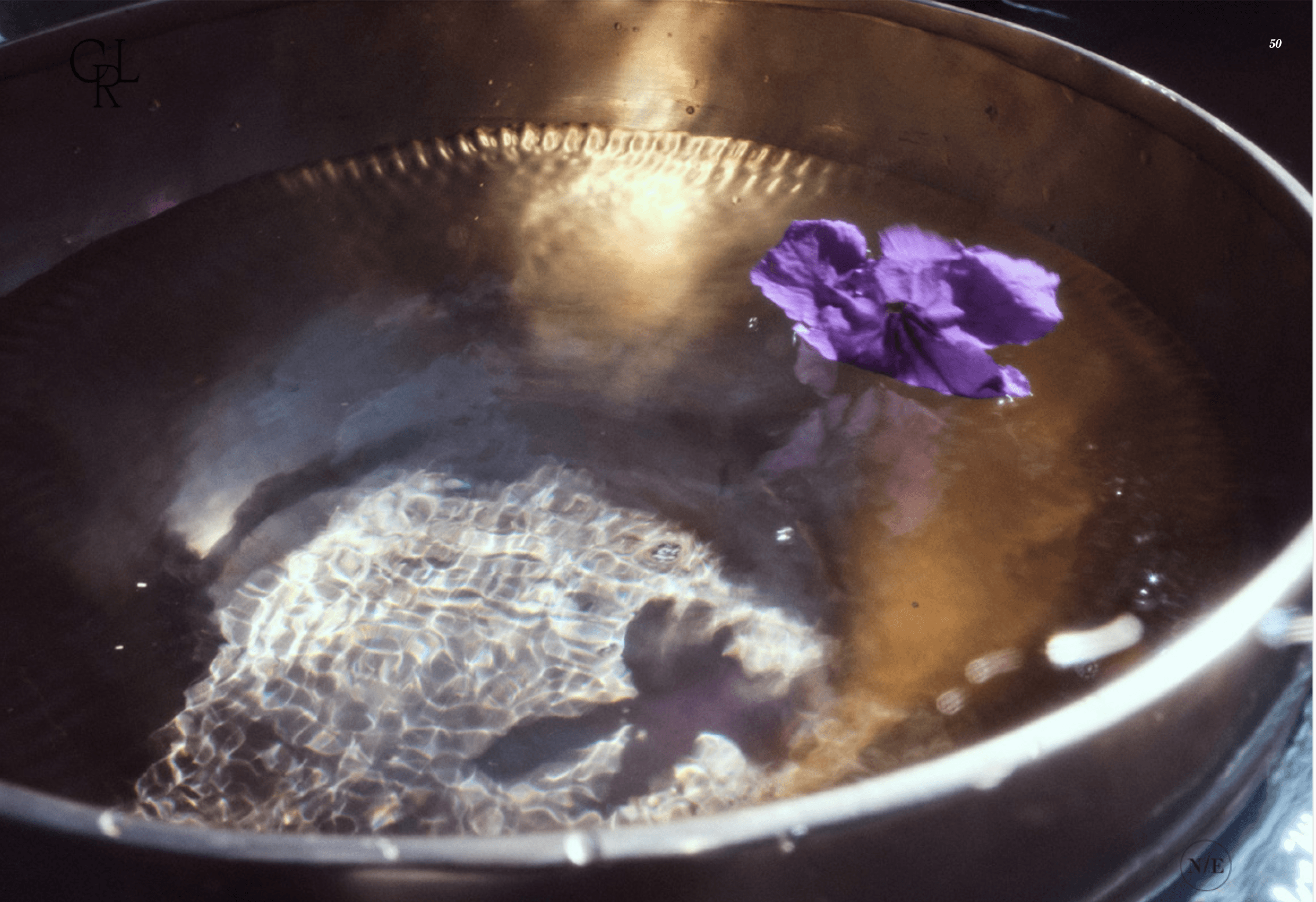 Cuenco tibetano lleno de agua con una flor, a la luz del sol